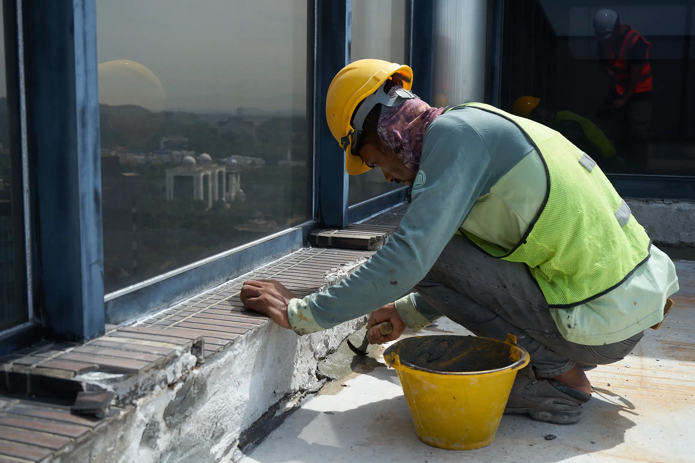 Worker carrying out concrete edge repair at a building opening